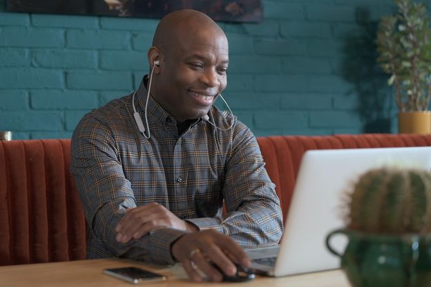 Man lachend en kijkend naar laptop