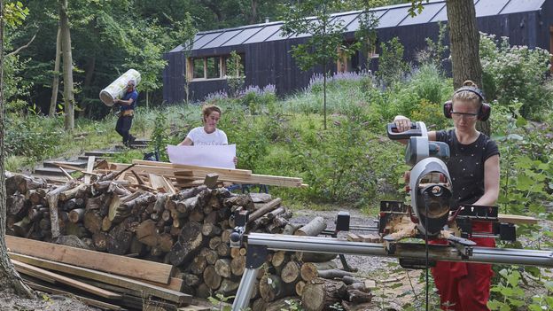 vrouw zaagt buiten hout