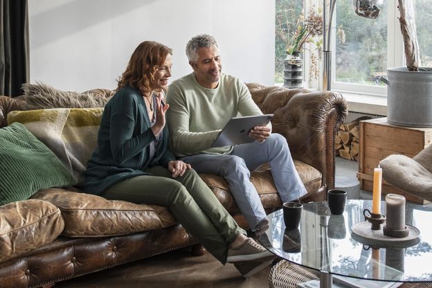 Man en vrouw op de bank kijkend naar tablet